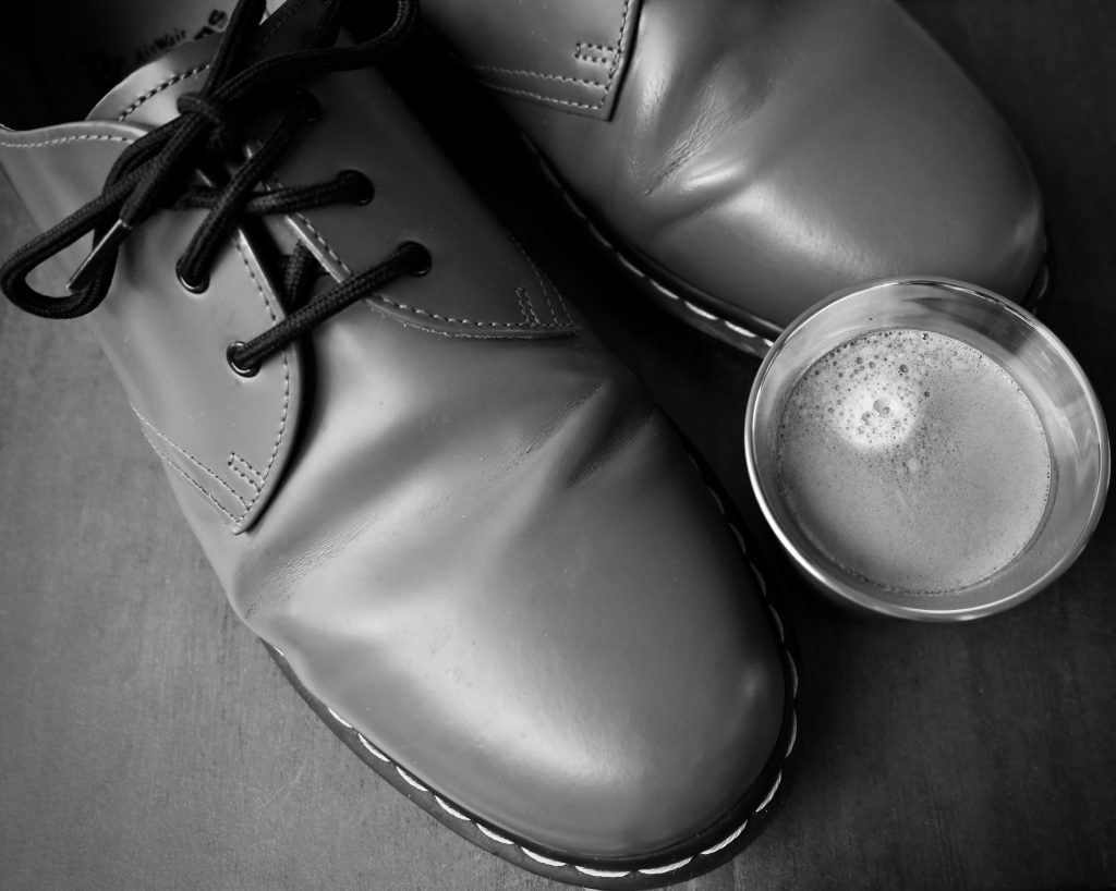 A close up of a pair of Dr Martin Shoes and an Espresso