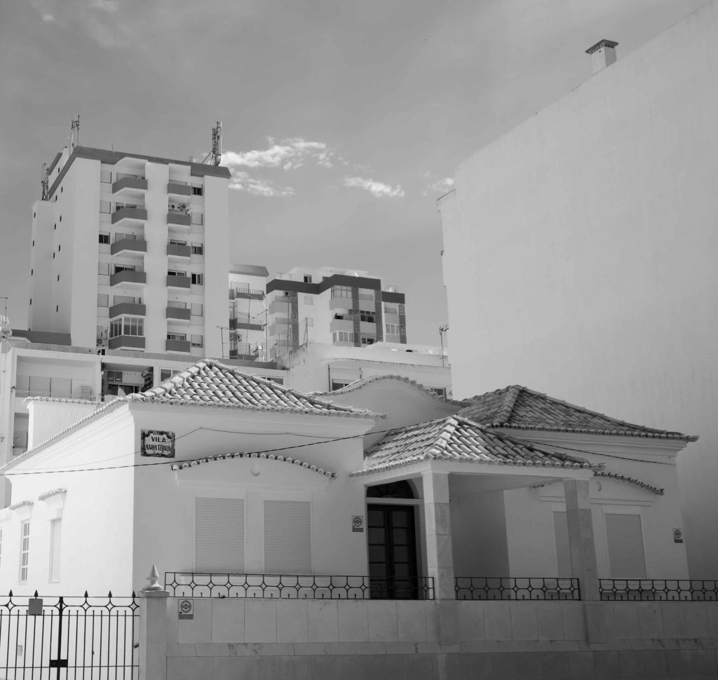 A single story house amongst high rise buildings