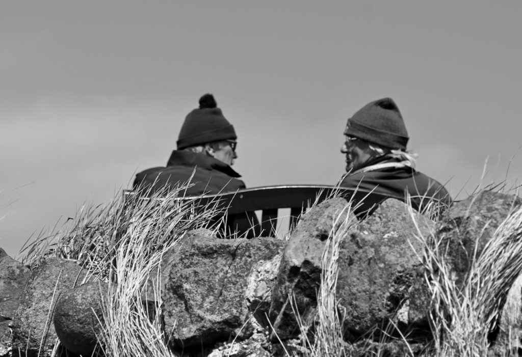 Two men talking on a bench